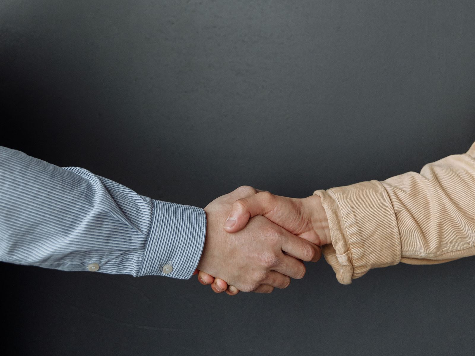 Zwei Personen geben sich die Hand – die persoenliche Zusammenarbeit von der ersten Idee bis zum Go-Live.